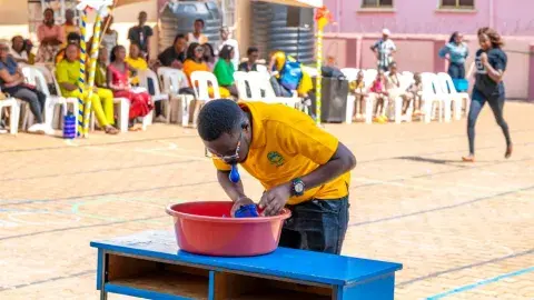 Parents vs teachers game - cup lifting with a balloon